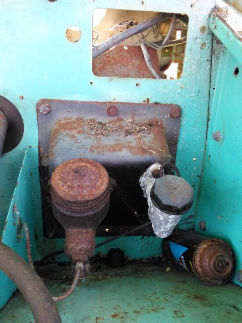 1991 Ford Bronco - Close-up view of corroded engine parts within a turquoise-painted compartment.