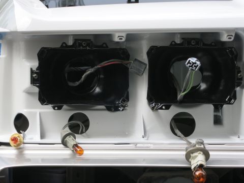 1991 Ford LTD Crown Victoria - Close-up view of the headlight housings and turn signal sockets, likely during a restoration or repair process.