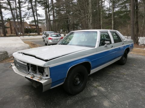 1991 Ford LTD Crown Victoria - A two-tone sedan sits in a driveway with the hood open and front end disassembled.