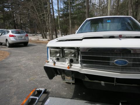 1991 Ford LTD Crown Victoria - Front view of a white 1991 Ford Crown Victoria LTD, showing its grille and headlights, with another vehicle in the background.