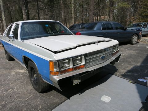 1991 Ford LTD Crown Victoria - This Ford Crown Victoria features a distinctive two-tone paint scheme and its hood is ajar, revealing the engine bay.
