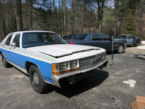 1991 Ford LTD Crown Victoria - Front view of a 1991 Ford Crown Victoria LTD undergoing work, with other cars in the background.