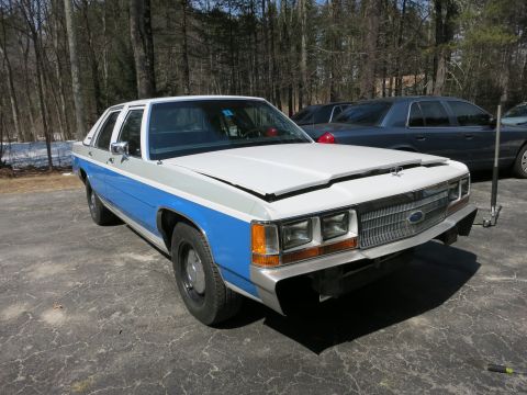 1991 Ford LTD Crown Victoria - A two-tone Ford Crown Victoria is parked on a driveway with the hood open, showing another car in the background.