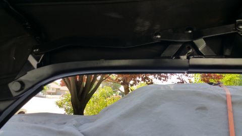 1963 Ford Falcon - View from inside a car, looking out through the window at trees and a suburban street.