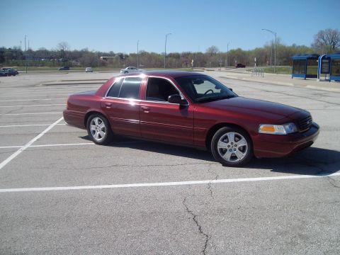 2004 Ford Crown Victoria - This red 2004 Ford Crown Victoria is seen from a three-quarter front view in a parking lot.