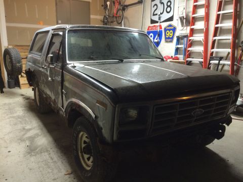 1986 Ford Bronco - This Ford Bronco appears to be undergoing disassembly in a garage setting.