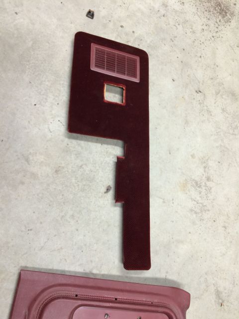 1986 Ford Bronco - A disassembled car door panel and vent are shown on a concrete surface.