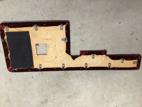 1986 Ford Bronco - A disassembled car door panel lies on a concrete surface, revealing its internal structure and attachment points.