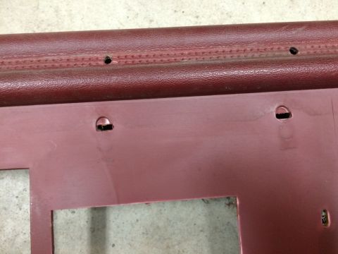 1986 Ford Bronco - Maroon interior door panel with visible mounting points and textured trim.