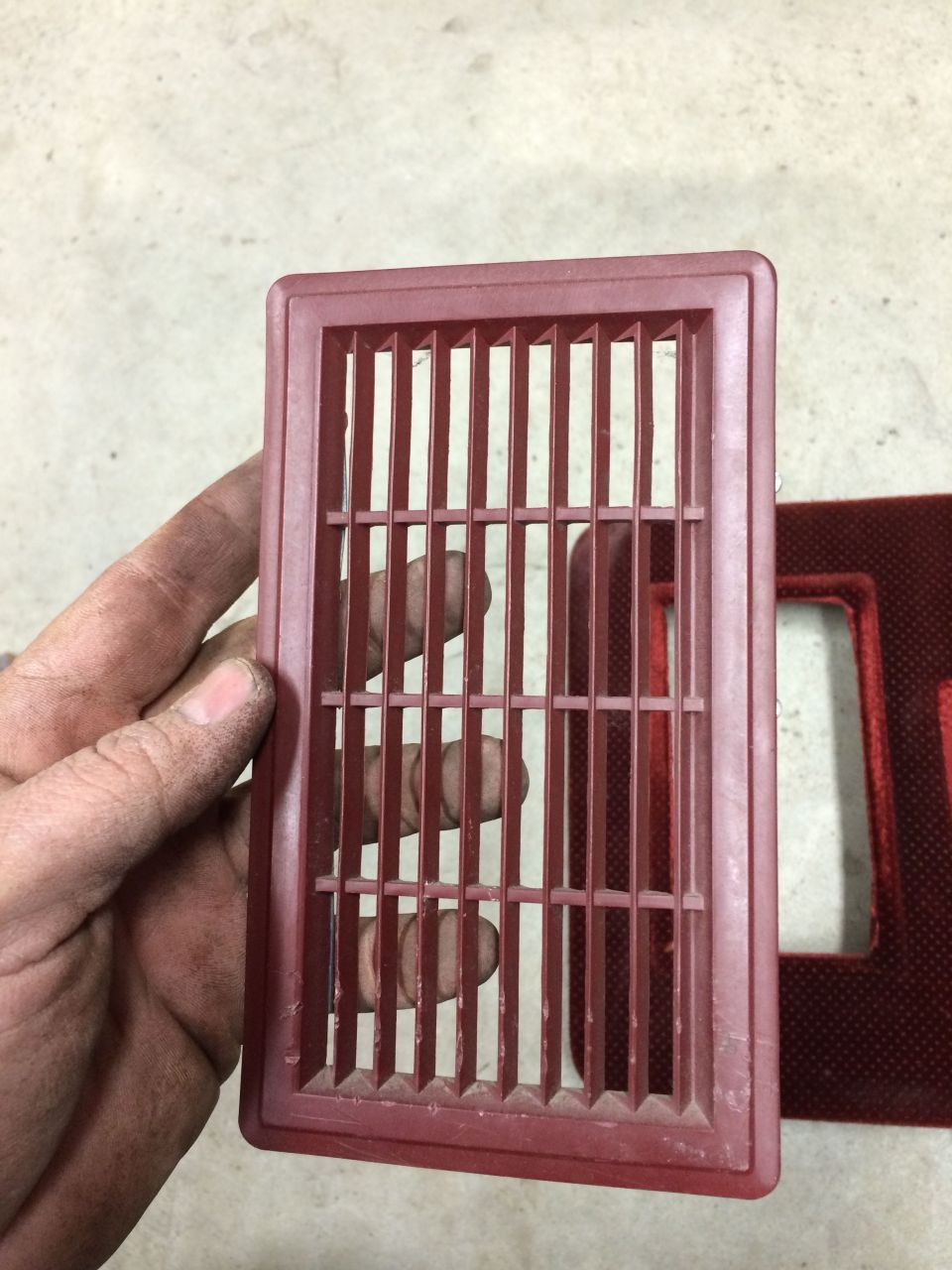 Red plastic vent held by a hand