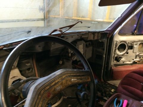 1986 Ford Bronco - The interior of a vehicle is shown with the dashboard and door panels disassembled, revealing internal components.