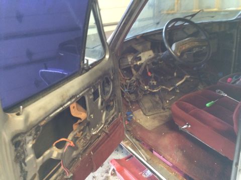 1986 Ford Bronco - The interior of a 1986 Ford Bronco shows a disassembled dashboard and maroon seats, indicating it is undergoing repairs or disassembly.
