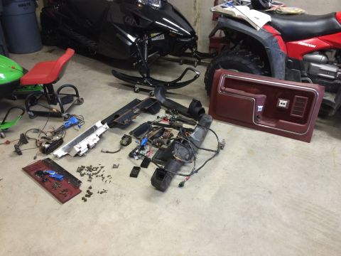 1986 Ford Bronco - Vehicle interior parts are laid out on the floor, suggesting a disassembly or repair process.