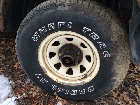 1986 Ford Bronco - A close-up view of a vehicle's tire and wheel, showing tread and sidewall markings.