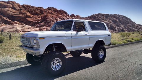 1979 Ford Bronco - This lifted 1978 Ford Bronco is parked on the side of a road with a desert landscape behind it.