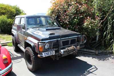 1989 Nissan Patrol - A 1989 Nissan Patrol is shown from the front-three-quarter view, equipped with off-road modifications.