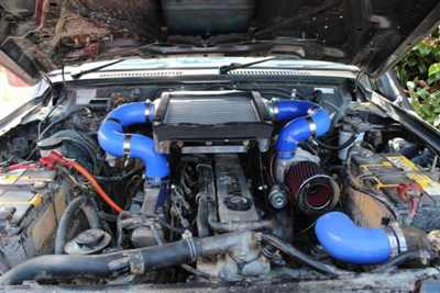 1989 Nissan Patrol - Customized engine bay prominent blue turbo piping and an aftermarket air intake system.