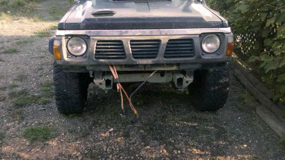 Front view of a dark-colored Nissan Patrol SUV with a modified bumper and large tires