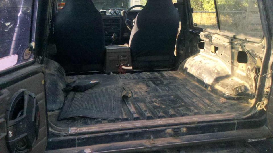 1989 Nissan Patrol interior, stripped rear cargo area, black seats, dashboard with gauges