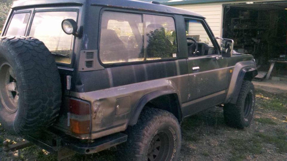Dark 1989 Nissan Patrol 3-door SUV with spare tire mounted on rear door
