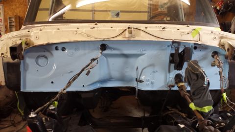 1978 Ford Bronco - The firewall of a vehicle's engine bay is painted light blue, showing exposed wiring and components during a restoration project.