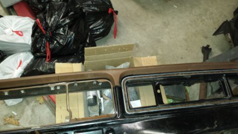1978 Ford Bronco - The interior of a vehicle is shown, with parts and trash bags in the background.