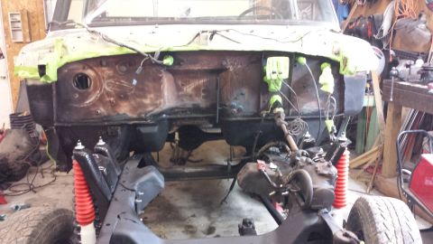 1978 Ford Bronco - The engine bay of a 1978 Ford Bronco is shown during a restoration, exposed components and red shock absorbers.
