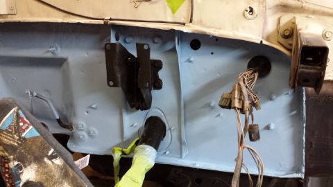 1978 Ford Bronco - This image shows the firewall area of a vehicle, including wiring harnesses and mounting brackets, during a repair or restoration.