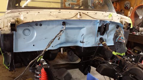 1978 Ford Bronco - The engine bay of a vehicle undergoing restoration, showing the firewall and various mechanical parts.