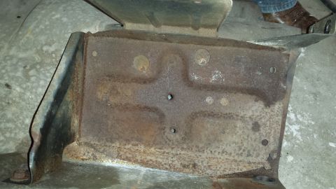 1978 Ford Bronco - Close-up view of a heavily rusted metal bracket, likely from a vehicle's undercarriage.