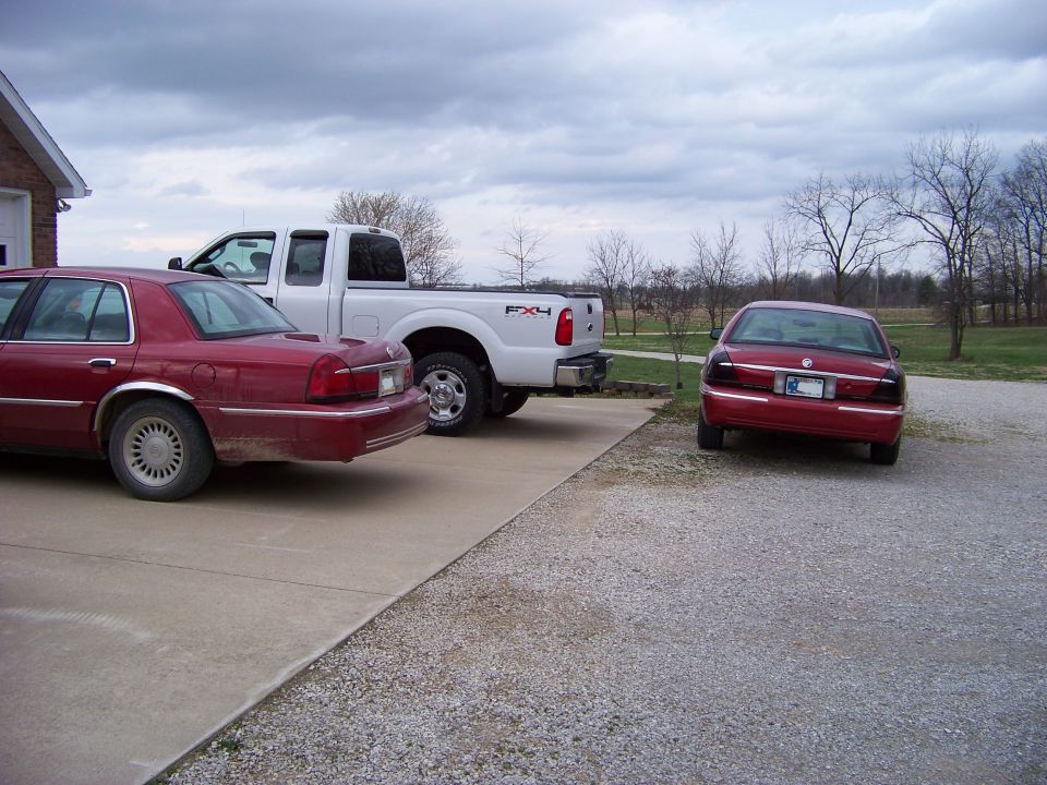 two red sedans and a white pickup truck parked in a driveway