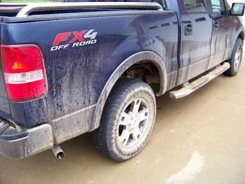 1999 Mercury Grand Marquis - Mud-covered blue pickup truck with FX4 Off Road badging.
