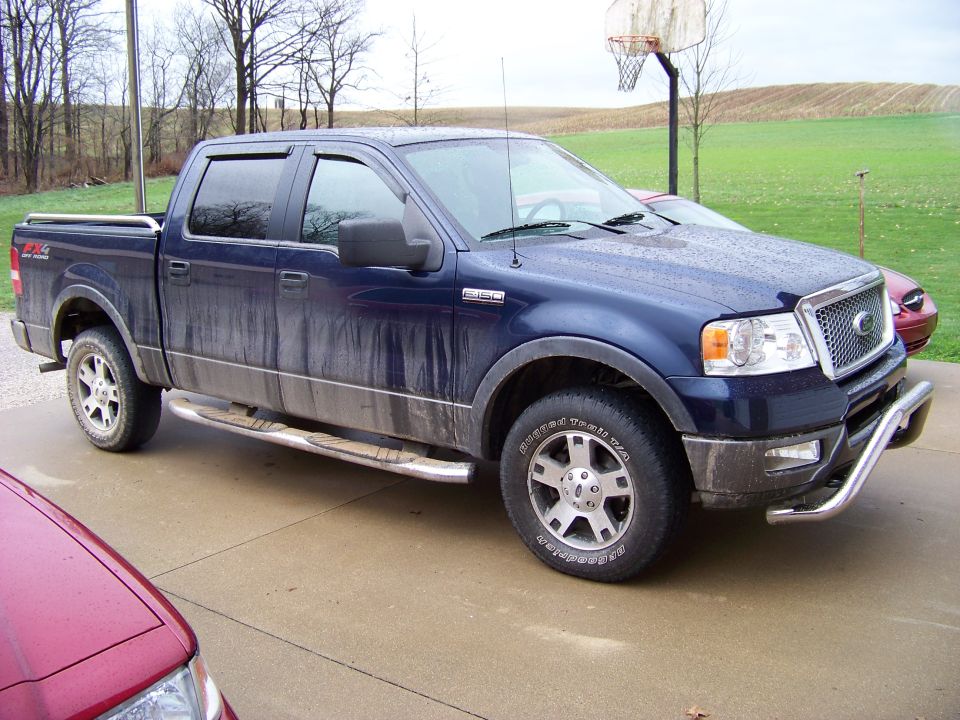 Blue pickup truck with chrome bull bar and running boards