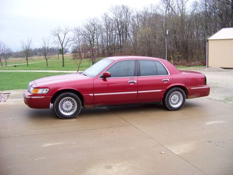 1999 Mercury Grand Marquis - This 1999 Mercury Grand Marquis is seen from the side on a cloudy day.