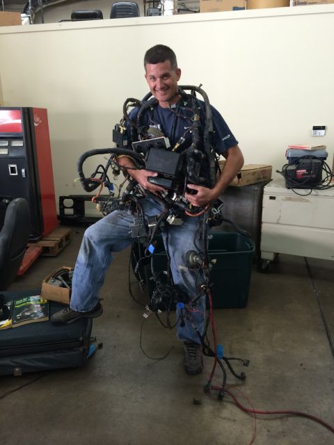 1992 Ford Bronco - Man models a full vehicle wiring harness, a complex assembly of wires and connectors.