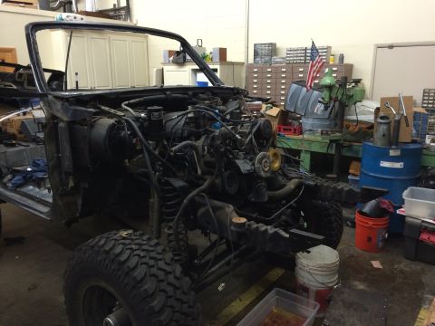 1992 Ford Bronco - The vehicle is in a state of disassembly, showing its frame, engine, and suspension components.