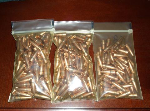 1995 Mercury Grand Marquis - Three bags of ammunition are displayed on a wooden table.