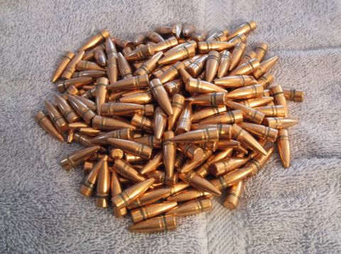 1995 Mercury Grand Marquis - A large pile of copper bullets rests on a textured gray surface.