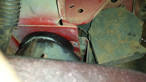 1991 Buick Reatta - This image shows a close-up view of a vehicle's suspension component, possibly a bushing, attached to red painted metal framing.