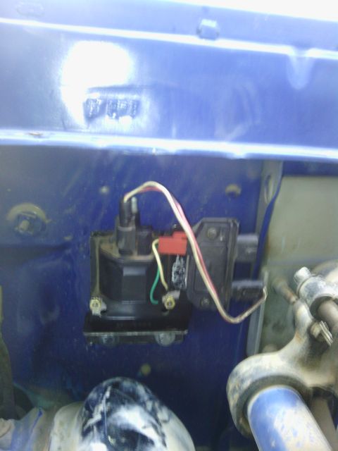 1978 Ford Bronco - This image shows a close-up view of an ignition coil and its wiring harness within a vehicle's engine bay.