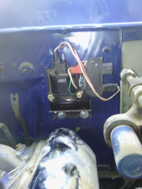 1978 Ford Bronco - Close-up view of an ignition coil and module mounted on a blue painted surface.