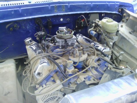 1978 Ford Bronco - Close-up view of a V8 engine bay, a carburetor and blue painted components.