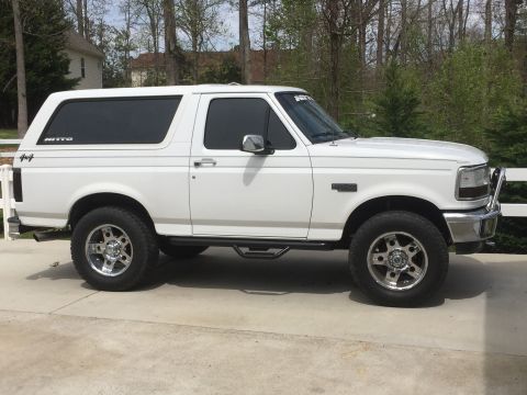 1995 Ford Bronco - This white 1995 Ford Bronco is shown from the side, aftermarket wheels and running boards.