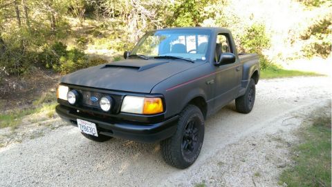 1991 Ford F-250 - This matte black Ford Ranger pickup truck has a custom hood scoop and fog lights.