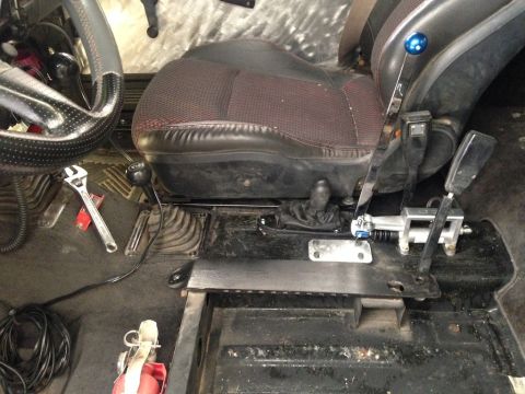 1987 Suzuki Samurai - Interior view shows dual shifters, a wrench, and a fire extinguisher on the floor.