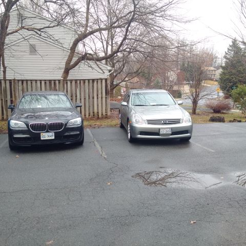 1978 Ford Bronco - Two sedans, a silver Infiniti and a black BMW, are parked side-by-side in an outdoor parking lot.