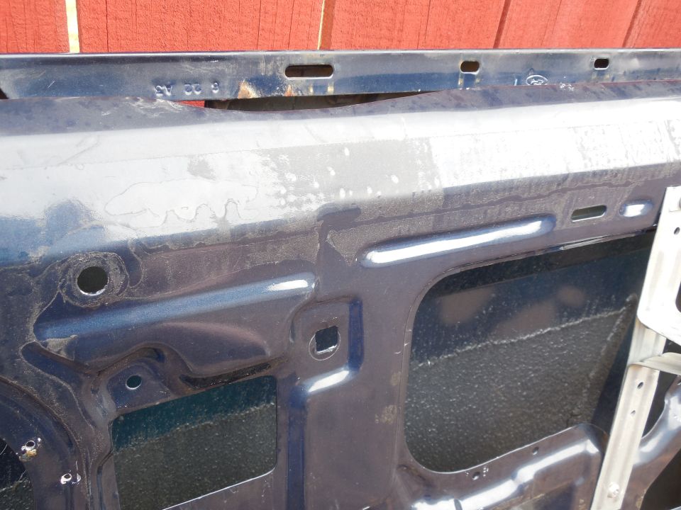 Door outer skin date stamp '93EB : 6 22 A3

The hole at the Left of the pic (above & rear of the speaker well) is for the flag/paddle-style mirror's inner brace arm bolt.  The square hole lower & farther back is for the vent window frame's bolt.