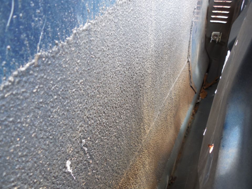 Close-up of dirty weathered blue vehicle body panel and edge gap