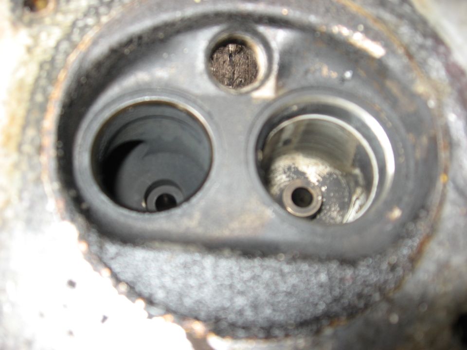 Engine cylinder head with two openings, one showing swirling marks, the other showing a valve seat