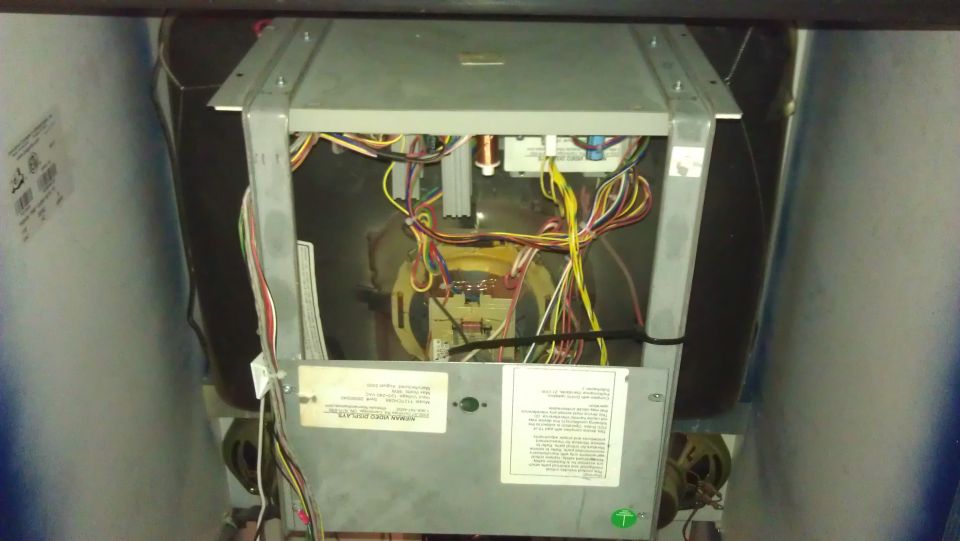 Inside of a machine showing wires, circuit boards, and labels
